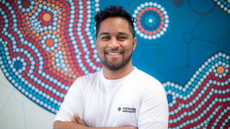 VU Sydney Student Mentor Nosad Hossain Midul standing in front of a mural