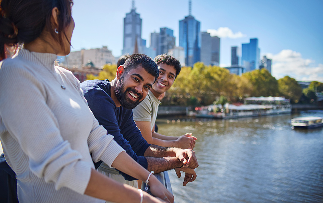 International students are sitting on bean bags at the Footscray Campus with one of the students looking very happy and smiling and looking into the camera