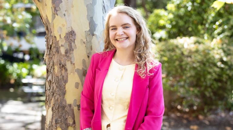 Student Recruitment Advisor Islay Gould standing outdoors and smiling at the camera