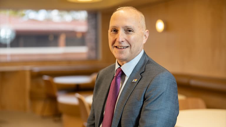 Senior Deputy Vice-Chancellor and Chief Academic Officer John Germov standing indoors and smiling at the camera