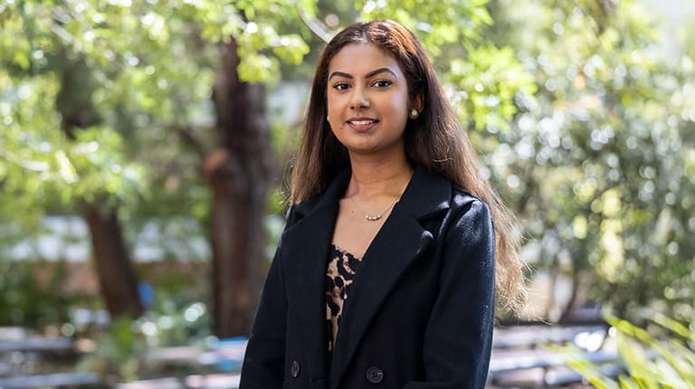 Asylum Seeker Fund recipient Shay Waran standing outside and smiling