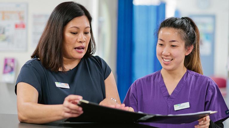  A nursing student and supervisor working in a hospital.