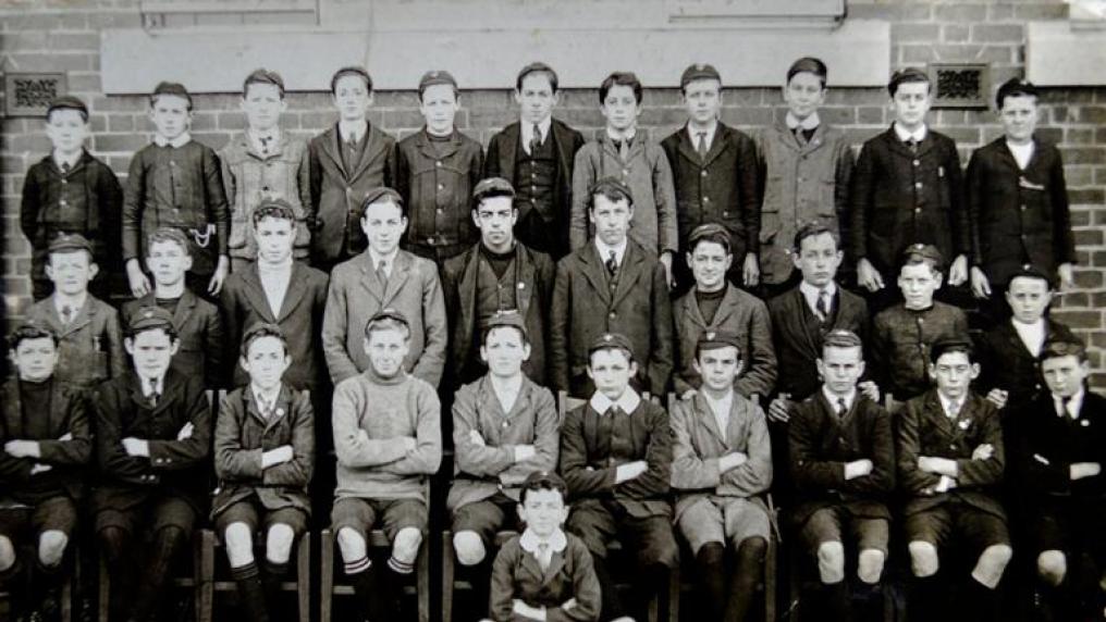 Black and white photo of young male students in suits