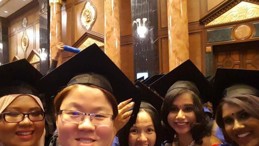Malaysia graduates taking a group selfie with five smiling graduates