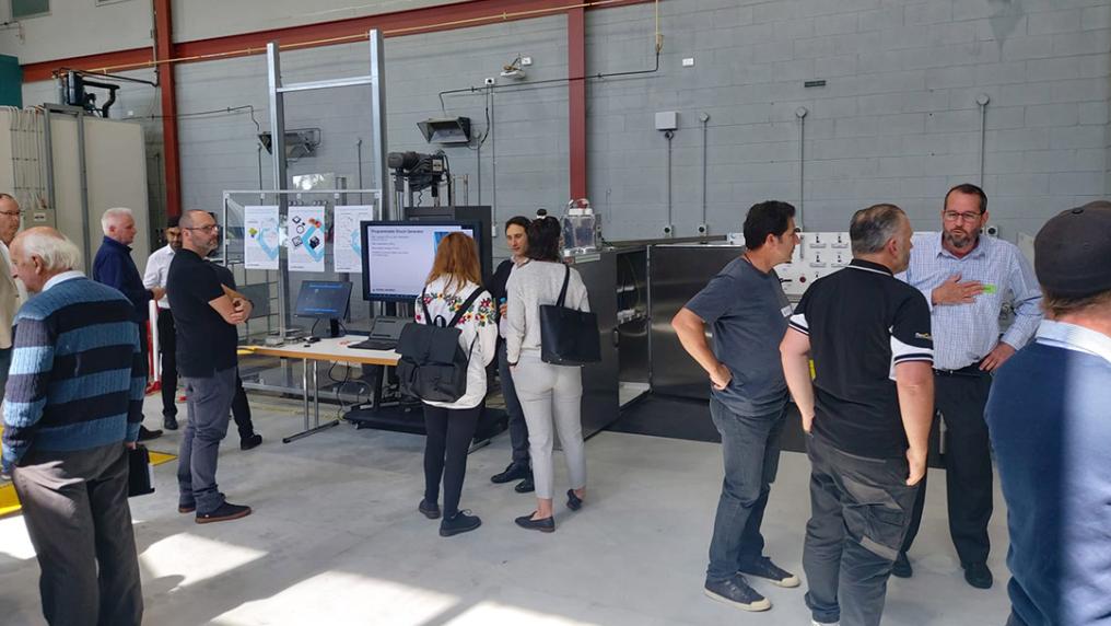A group of people talk in a large laboratory