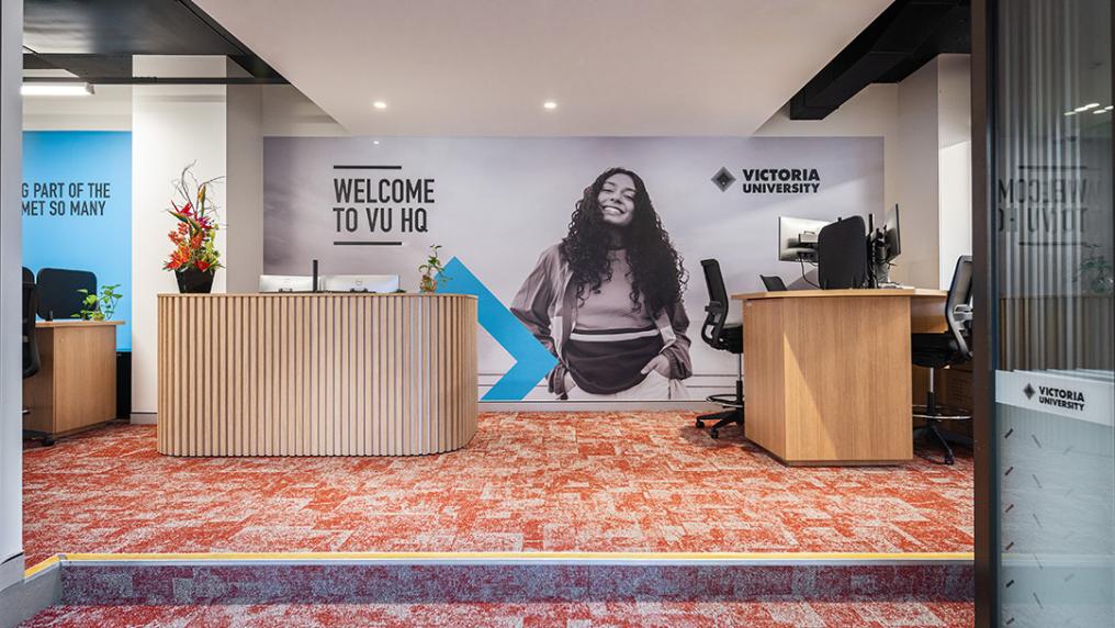 VU Brisbane campus foyer with welcome desk and VU signage.