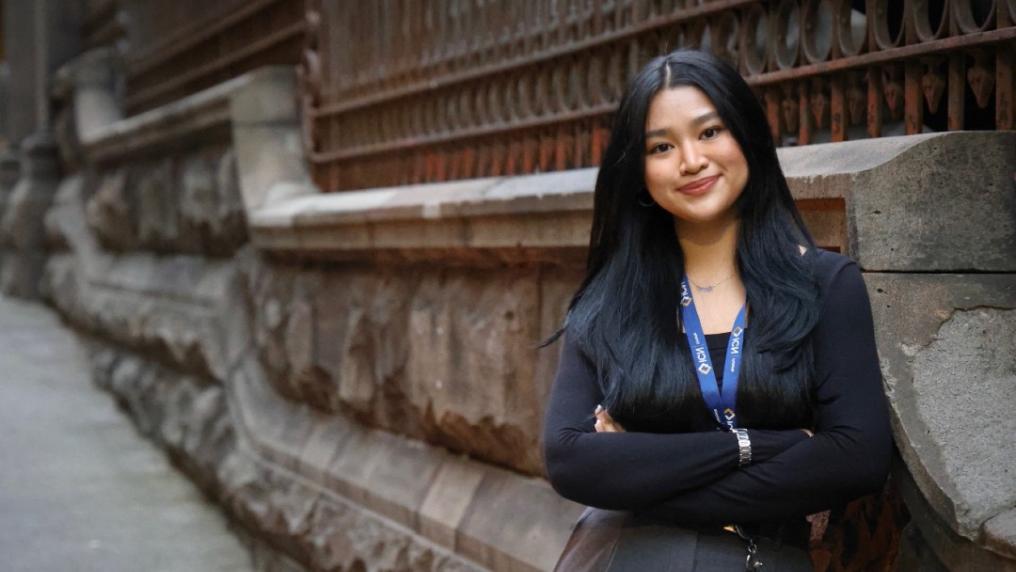VU Student Samantha Espiritu leaning against a stone bridge
