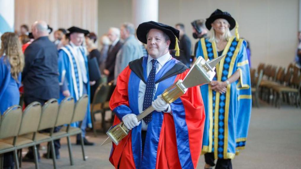 Academic carrying the University Mace